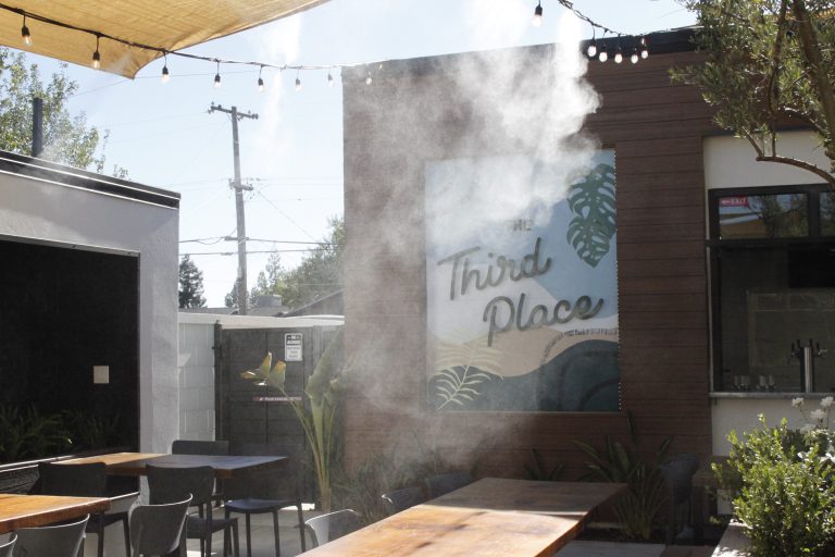 The outdoor patio of Third Place, which holds seating for guests to sit and eat together or enjoy a drink from the bar. The area also has water misters to spray refreshing water to stay cool while you eat (Photo by Hannah-Grace Leece, Clovis Roundup).
